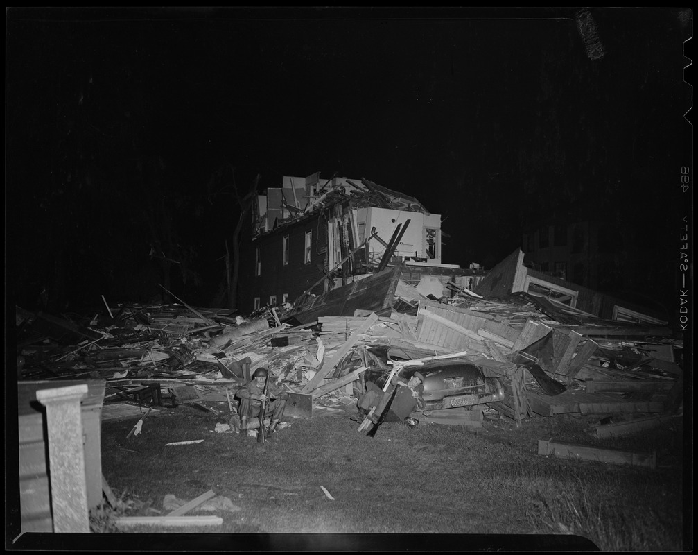 Military man sitting in front of building wreckage - Digital Commonwealth