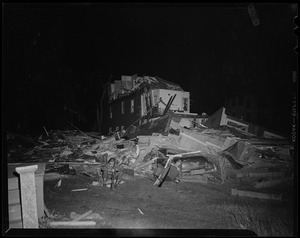 Military man sitting in front of building wreckage