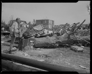 Man with one leg resting on tree stump, looking at damage