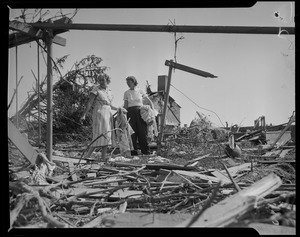 Two women gathering items from the wreckage caused by the tornado