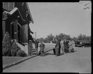 Pallbearers with coffin, walking into a church