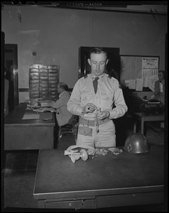 Military man holding tangled necklaces and other found jewelry and items