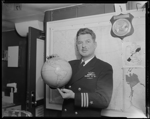 Navy officer holding the globe with his two pointer fingers