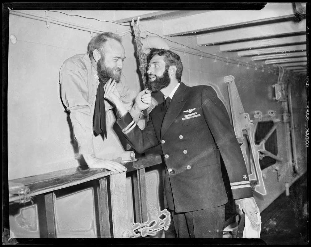 Navy officers touching each other's beards in fun