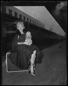 Eva Gabor, seated with her dog Delilah on her lap
