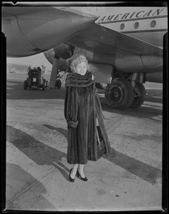 Zsa Zsa Gabor posing in front of airplane