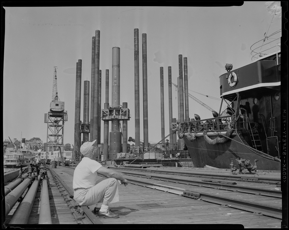 Man sitting and looking up at ship