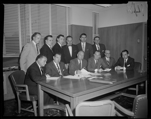 Group of twelve men sitting and standing around a table including in front row (l. to r.): Reps. Harry Coltun, John F. Thompson, Dr. William H. Turville, Charles Gibbons, Charles Ferguson and James L. O'Dea
