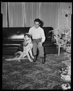 Tony DeSpirito sitting on a couch with a dog in front