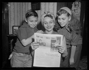 Tony DeSpirito's mother, brother Barry, and sister Barbara looking at a newspaper