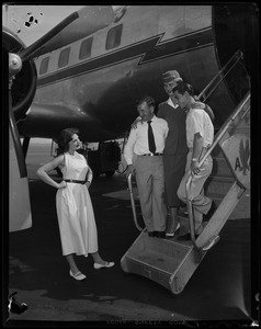 Tony DeSpirito and Harold "Red" Keene descend airplane stairs with flight attendant while Doris DeSpirito looks on