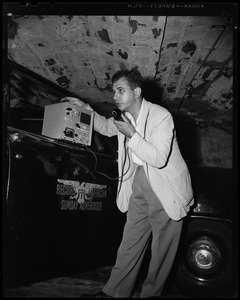 Man using a radio instrument, most likely provided by the Record American Sunday Advertiser