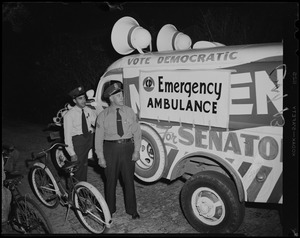 Two uniformed men standing next to a Democratic nominee vehicle, turned into an emergency ambulance