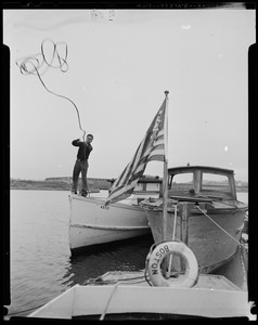 Man on boat number 4D331, throwing a rope in preparation for Hurricane Edna