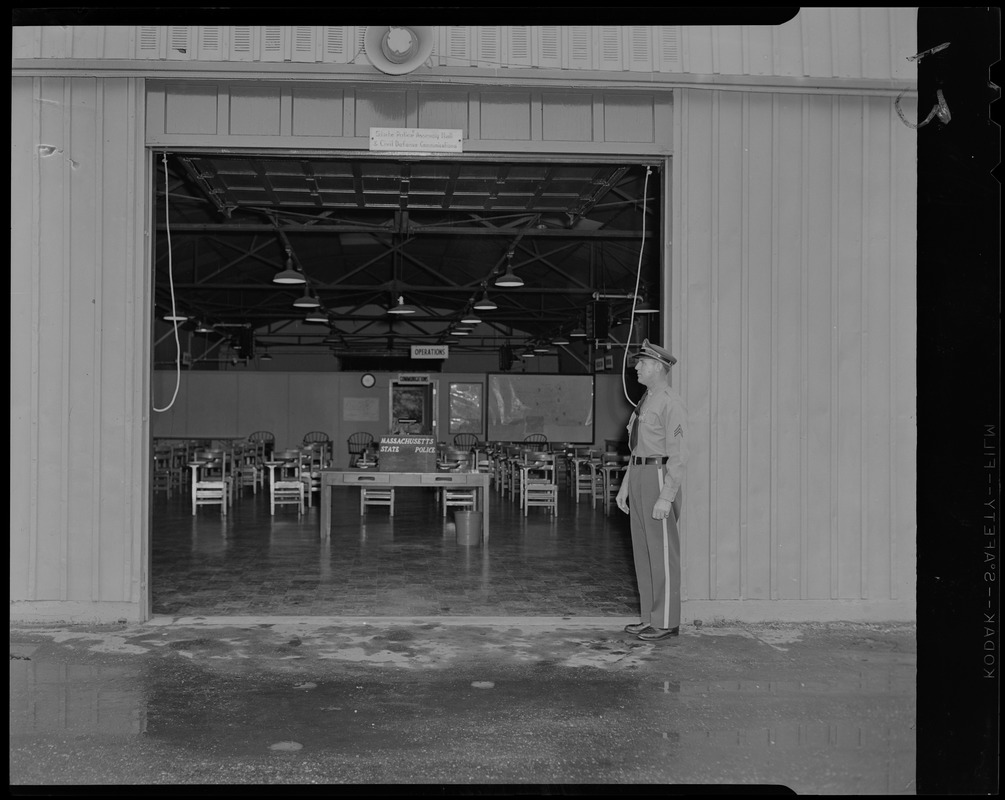 Sgt. Raymond D. Alzapiedi, instructor at State Police training school, Framingham, standing at Control Room (usually used for classroom) entrance