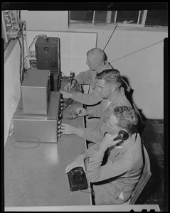 State Police trainees George Cassell, John L. Lacasse, and Francis Carlston, manning telephones and short wave machines, at Civilian Defense Control room, rear of State Police Headquarters, Framingham