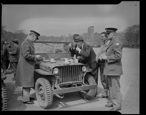 Leverett Saltonstall eating with others, using the hood of a military jeep as a tabletop