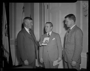 Leverett Saltonstall with two men, holding a Blue Cross booklet