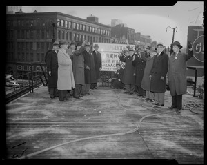 Group of men in coats on elevated platform