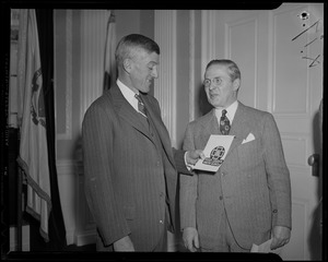 Leverett Saltonstall with two men, holding a Blue Cross booklet