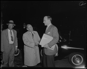 Adlai Stevenson shaking hands with his son Adlai Stevenson III outside next to a car