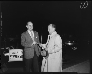 Adlai Stevenson handing his son Adlai Stevenson III a cigar