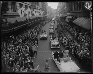 Adlai Stevenson in first car of campaign motorcade with crowds on either side