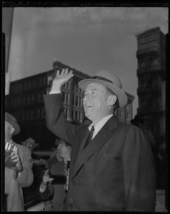 Adlai Stevenson waving to crowd, with hat on his head