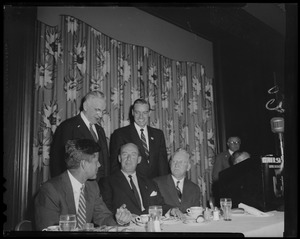 John F. Kennedy, Adlai Stevenson, and Mayor John B. Hynes seated at dinner table with Edward McCormack, (standing, right) and one other standing behind them