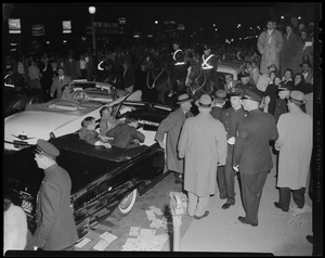 Adlai Stevenson exiting a convertible as mounted police watch