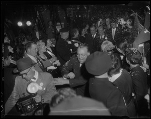 Man pushing through the crowd in procession ahead of Adlai Stevenson, Paul Dever and John F. Kennedy