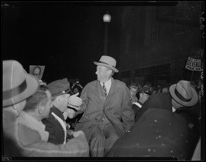 Adlai Stevenson seen in crowd shaking hands with those around him