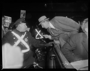 Adlai Stevenson talking to a police officer from a convertible