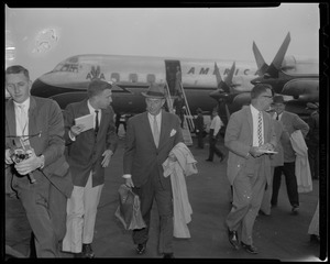 Adlai Stevenson walking away from airplane with others