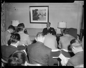Adlai Stevenson speaking before a group of people in a room