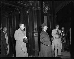 Adlai Stevenson waiting with three other men inside entrance of a room