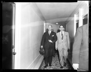 Adlai Stevenson and another man walking down a hallway