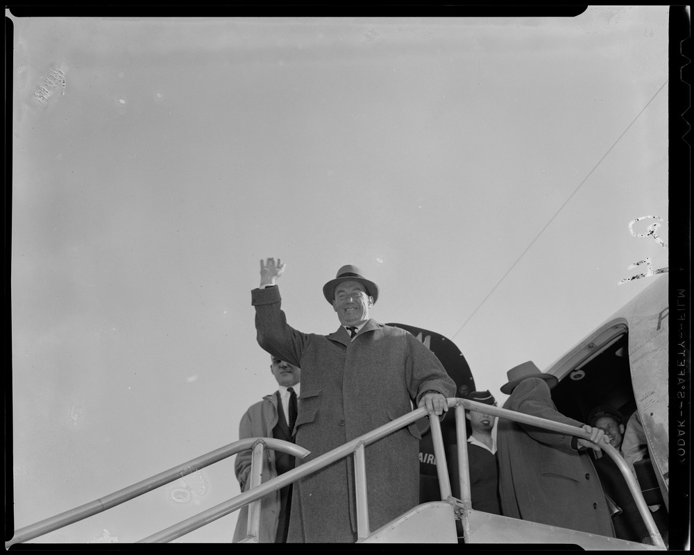 Adlai Stevenson standing on airplane stairs