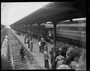 Group of people standing on a train station platform as "Adlai Stevenson Special" train arrives