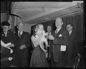Adlai Stevenson speaking to a woman holding a baby