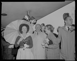Adlai Stevenson, Nancy Anderson Stevenson and Adlai Stevenson III standing with a woman with an umbrella