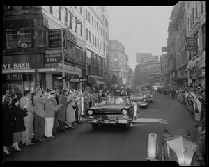 Adlai Stevenson waving from front car in a parade