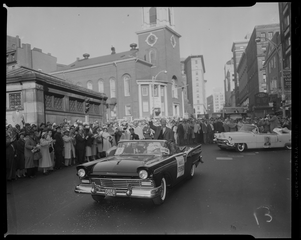 Adlai Stevenson waving from front car in a parade