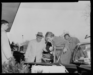 Adlai Stevenson helping his daughter-in-law, Nancy Anderson Stevenson, out of a car