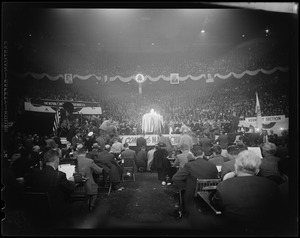 View of a speaker at a podium in the stadium filled with people