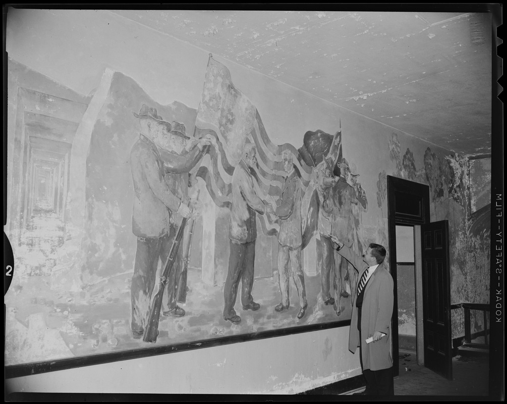 Man looking at a mural on a wall depicting soldiers and the American flag