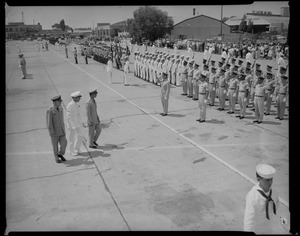 Groups of uniformed people standing at attention and saluting King Bhumibol Adulyadej and Queen Sirikit of Thailand upon their arrival