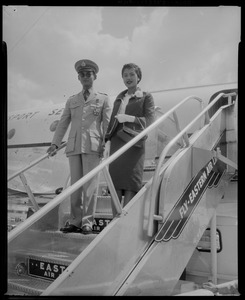 King Bhumibol Adulyadej and Queen Sirikit of Thailand standing on airplane stairs