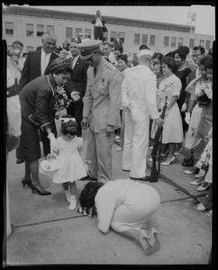 Girl watching while a woman kneels on the ground in front of King Bhumibol Adulyadej and Queen Sirikit of Thailand