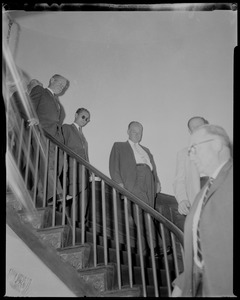 King Bhumibol Adulyadej of Thailand walking down stairs with a group of men